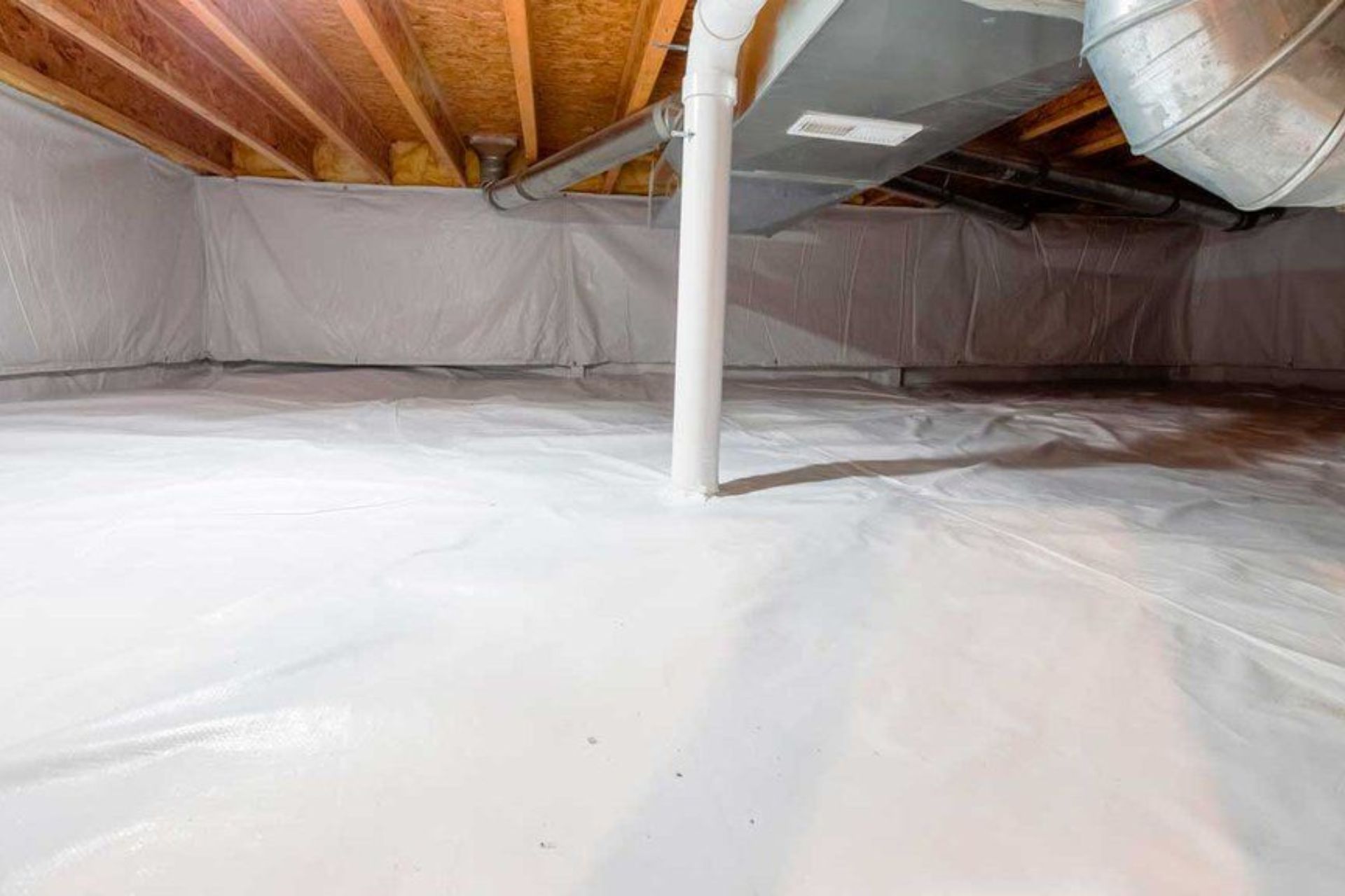 Clean, well-lit basement with a white vapor barrier covering the ground, exposed wooden beams, and ductwork overhead.